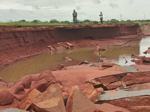 Uma margem de rio íngreme de terra vermelha, muito erodida