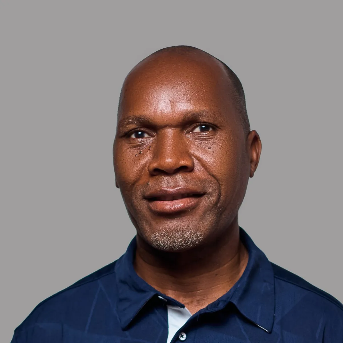 Abrão Mahumane sorridente, com um pólo azul-marinho